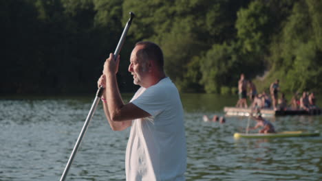 Paddleboarding.-An-older-man-standing-on-a-paddleboard