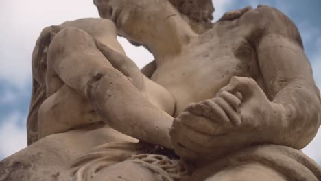 Ancient-statue-of-woman-and-man-kissing-with-passion,-close-up-motion-view