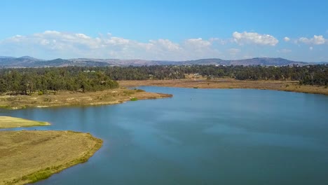 Drone-footage-moving-straight-up-revealing-Lake-Dyer-and-surrounds,-including-mountains-in-the-distance