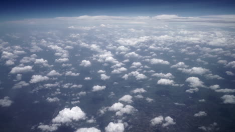Blick-Aus-Einem-Flugzeugfenster-Auf-Kleine-Weiße-Wolken-über-Dem-Wald
