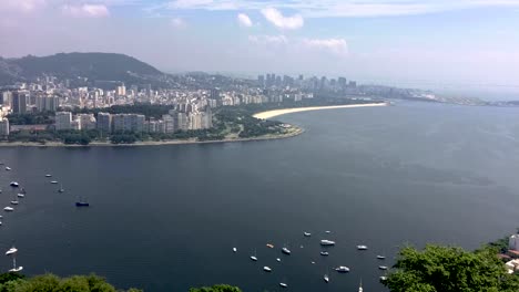 Zeitraffer-Mit-Ein--Und-Auslaufenden-Booten-Im-Botafogo-freizeithafen-In-Rio-De-Janeiro,-Die-Muster-Im-Wasser-Mit-Dem-Stadtzentrum-Im-Hintergrund-Bilden