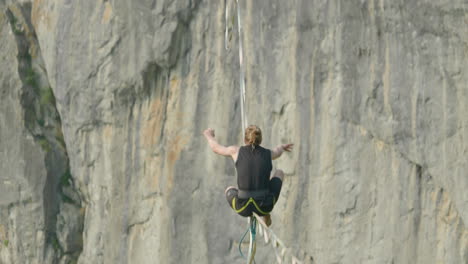 Athlete-on-high-line-slack-line-over-cliff-in-Germany