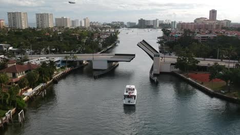 Aerial-of-big-boat-driving-under-a-bridge-as-is-rises