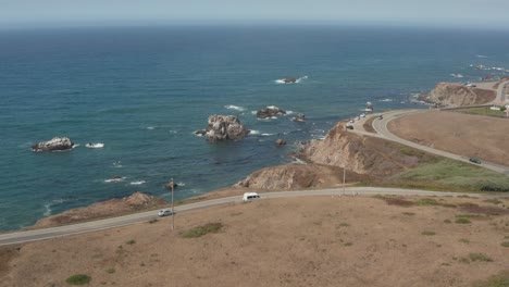 Aerial-view-of-cars-driving-down-Highway-1-by-the-ocean-Bodega-Bay-n-Northern-California