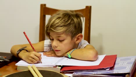 Dolly-shot-of-young-boy-doing-homework-at-kitchen-table