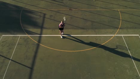 Aerial-footage-of-a-female-tennis-player-playing-tennis-on-a-tennis-court