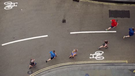 Slow-motion-wide-aerial-view-of-runners-on-street-in-the-rain