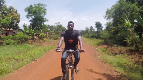 A-stabilized-following-shot-of-a-young-man-riding-through-rural-village-in-Africa