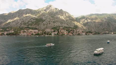 Ships-sailing-off-the-coast-of-a-stunning-mountainous-town-in-Montenegro