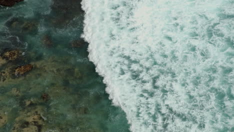 Olas-Del-Océano-Rodando-Hacia-La-Costa-Desde-Una-Vista-De-Pájaro-Que-Muestra-Arrecifes-Y-Rocas