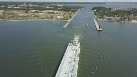 Aerial-view-of-large-freighter-moving-out-of-canal-in-Michigan,-USA