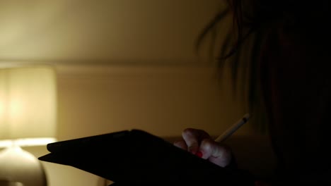 Close-Up-Young-Woman-Using-a-Tablet-at-Night