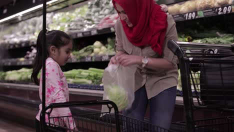 Mother-and-daughter-shopping-for-lettuce-at-the-grocery-store