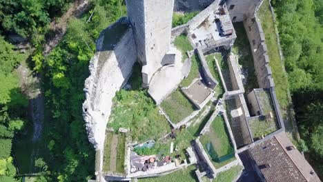 Aerial-view-of-Castel-Telvana-in-Borgo-Valsugana,-Trentino,-Italy-with-drone-flying-down-and-tilting-up-to-reveal-the-tower