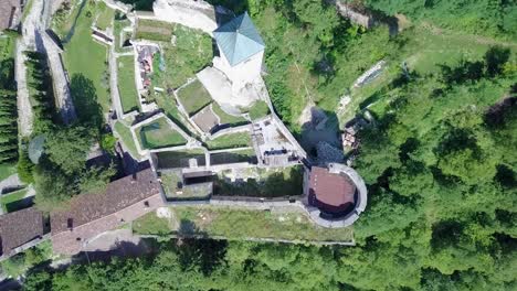 Aerial-top-view-of-Castel-Telvana-in-Borgo-Valsugana,-Trentino,-Italy-with-drone-flying-up-and-rotating