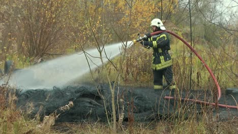 Feuerwehrleute-Richten-Wasserstrahl-Auf-Brennendes-Haus