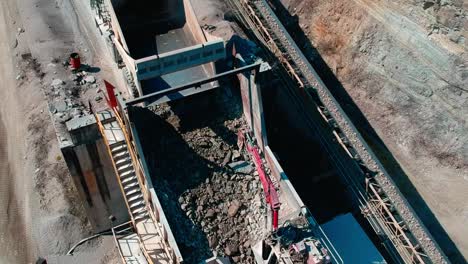 Large-dump-truck-dumping-a-load-of-limestone-into-a-crusher