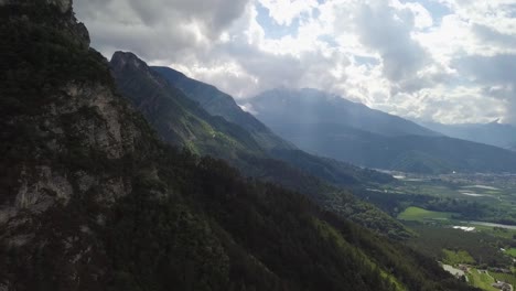 Vista-Panorámica-Aérea-De-Las-Montañas-Y-El-Valle-En-Borgo-Valsugana,-Trentino-Italia-Con-Drones-Volando-De-Lado-En-Un-Día-Claro-Y-Soleado