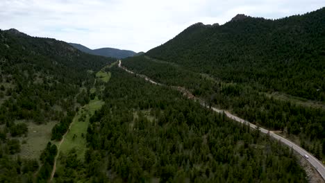Panoramic-View-Of-Deciduous-Forest-Trees-And-Mountains-With-Country-Road-Near-Estes-Park,-Colorado