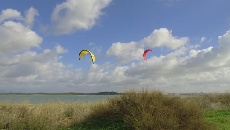 Clases-De-Kite-Surf,-Gente-Entrenando-En-La-Laguna-Con-El-Kite-Surf,-Velas-Detrás-De-La-Duna