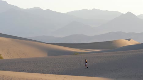Woman-walking-in-the-desert-early-morning-in-Death-Valley-National-Park-in-California,-USA