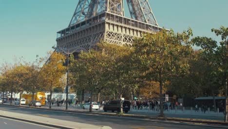 Tilt-shot-showing-Eiffel-Tower-surrounded-by-tourists-and-traffic-in-foreground