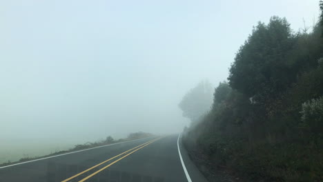 Driving-in-dangerous-foggy-weather-conditions-on-highway,-as-seen-from-inside-the-car