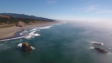 Antenne:-Beim-Fliegen-über-Die-Küste-Von-Oregon-Schlagen-Die-Wellen-Gegen-Die-Küste,-Während-Der-Nebel-Hereinrollt
