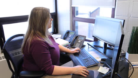 Mujer-Escribiendo-En-Su-Computadora-En-Una-Pequeña-Oficina