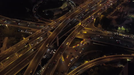 Aerial-shot-of-multi-layer-express-road-junction-at-night-with-heavy-traffic