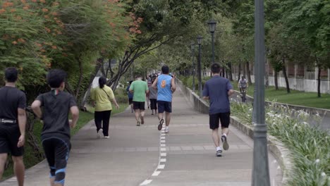 Un-Grupo-Saludable-De-Personas-Trotando-En-La-Vía-En-El-Parque-Banjakiti-En-Bangkok,-Tailandia