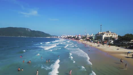 4k-Aerial-Shot-Showing-Beach-with-People-and-Waves-in-Florianopolis,-Brazil