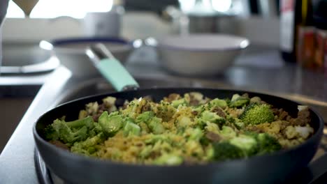 Sprinkling-salt-on-dish-rice-broccoli,-curry-and-meat-in-kitchen-of-motorhome