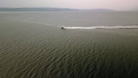Aerial-Daytime-Wide-Shot-Flying-Over-Green-Ocean-Following-A-Fishing-Power-Boat-Wake-Waves-With-Hazy-Hills-In-Background-At-Sunset-In-Gulf-Islands-British-Columbia-Canada