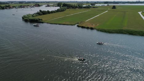 Aerial-Slomo-panning-around-Small-Boat-with-5-Male-Friends-Sailing-surrounded-by-other-boats-Dutch-Countryside-during-Hot-Weather