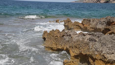 Waves-in-blue-water-clash-onto-rocky-beachside-Mallorca-Spain-balerica-island
