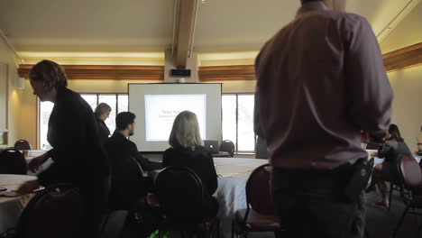 Group-of-business-people-listening-to-a-keynote-speaker-give-a-presentation