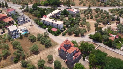 Aerial-pan-down-shot-to-show-a-typical-Greek-church-on-Thassos-island,-Greece