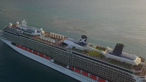 Aerial-close-up-view-and-fly-over-a-big-cruise-ship-in-leaving-the-dock-on-a-sunny-day