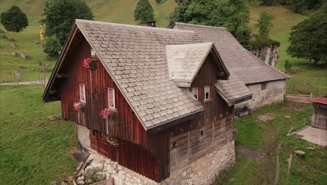 Casa-De-Campo-De-Madera-Romántica-En-Las-Montañas-Suizas,-Vuelo-Aéreo-De-Drones