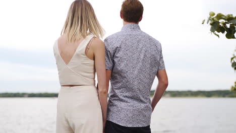 Attractive-young-couple-staring-out-across-a-beautiful-lake