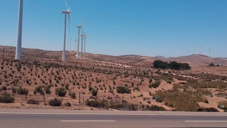 Highway-and-eolic-turbines-in-dry-land,-Chile