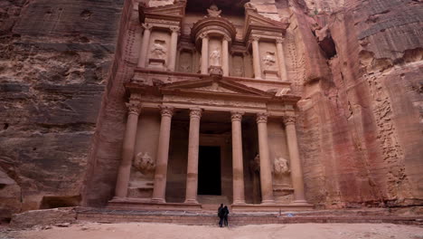 Panoramaaufnahme-Der-Aus-Einem-Sandstein-Gehauenen-Fassade-Der-Schatzkammer-In-Der-Antiken-Stadt-Petra-Mit-Touristen-Im-Hintergrund