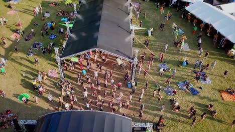 festival-with-dancing-people-in-front-of-a-stage-in-the-swiss-Jura-mountains-with-the-drone-from-the-air-filmed