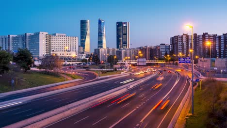 Madrid-four-towers-at-sunset,-highway-in-the-foreground,-rush-hour