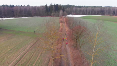 Colorful-dressed-person-run-between-brown-fields-on-ground-path