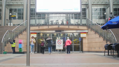 ZOOM-OUT-on-Canary-Wharf-London-shopping-centre-entrance-with-large-digital-advertising-display