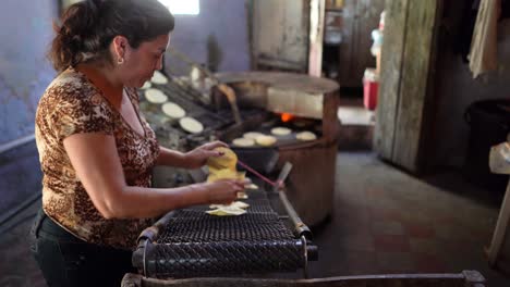 Camera-moves-from-a-stack-of-freshly-made-tortillas-to-a-woman-who-is-pulling-them-off-of-a-conveyor-belt