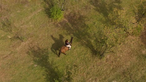 Aerial-tracking-drone-shot-of-girl-ride-disobedient-horse