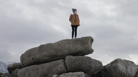 A-girl-stands-on-boulders-and-enjoys-the-view